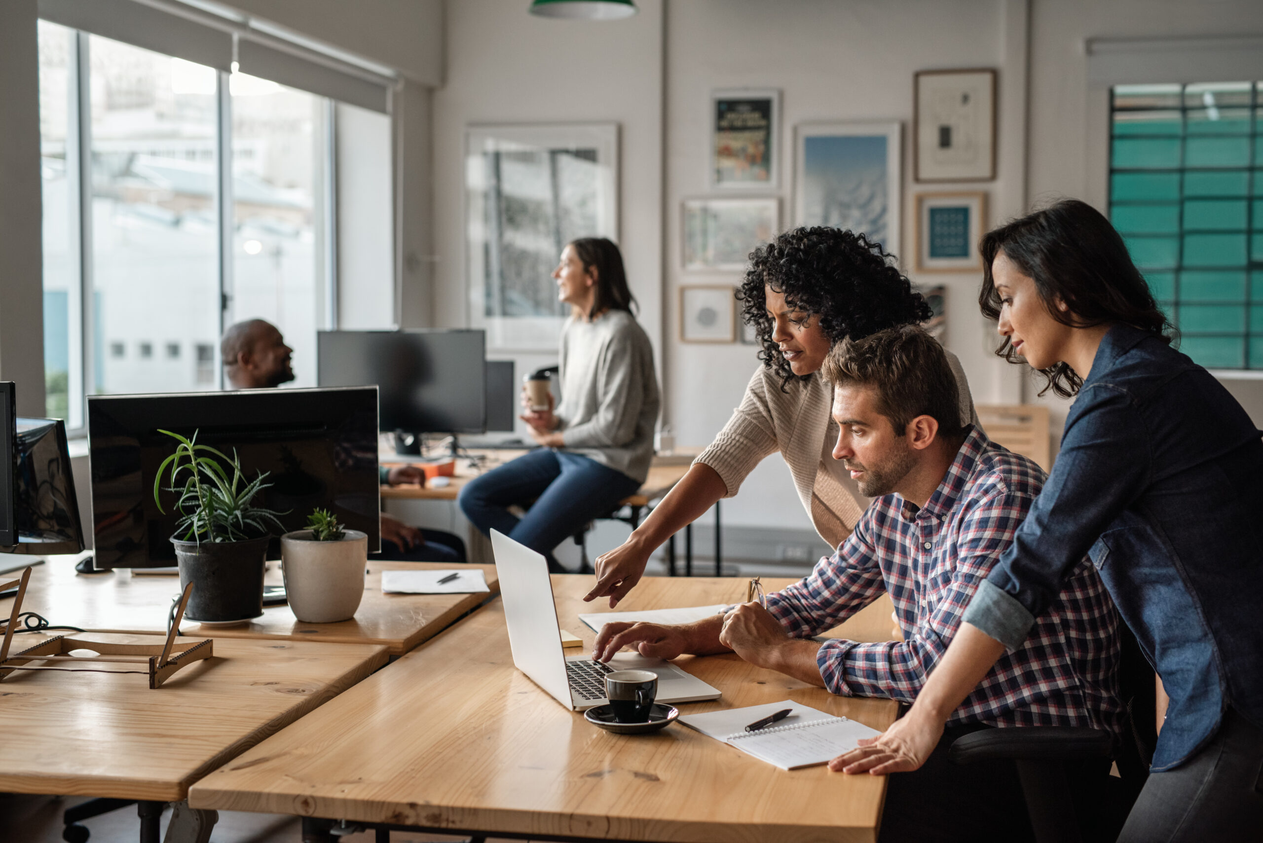Three young designers using a laptop together at work Connecting People